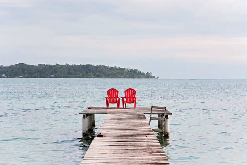 A Dock, Two Red Chairs, and a Wide Open Ocean