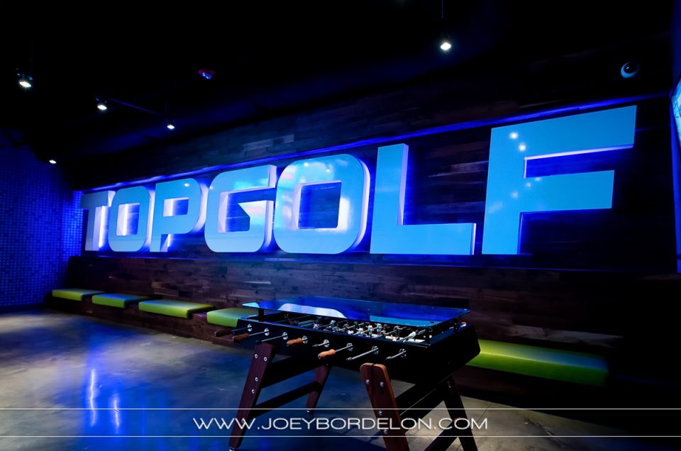 Top Golf Baton Rouge bar area's sign and game table